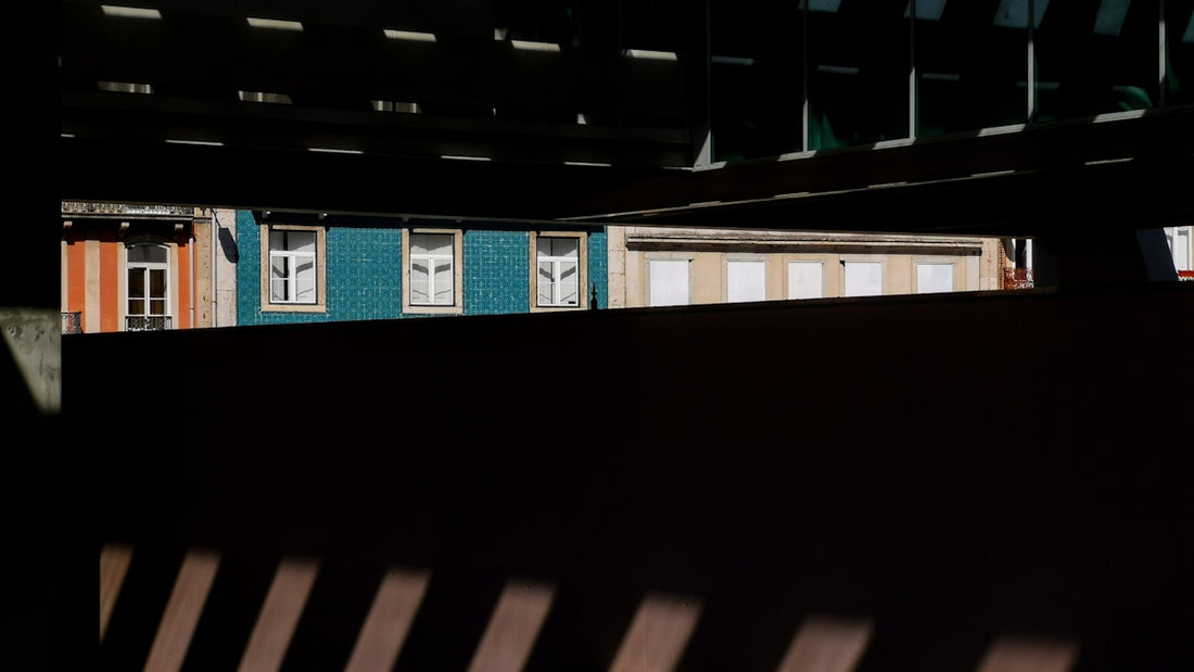 a train traveling past a train station next to a tall building