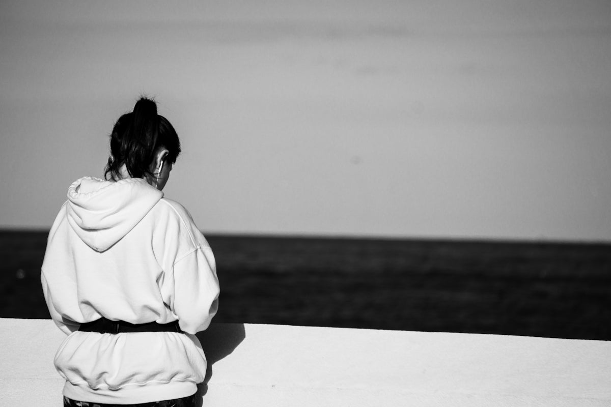 woman in white shirt sitting on sand