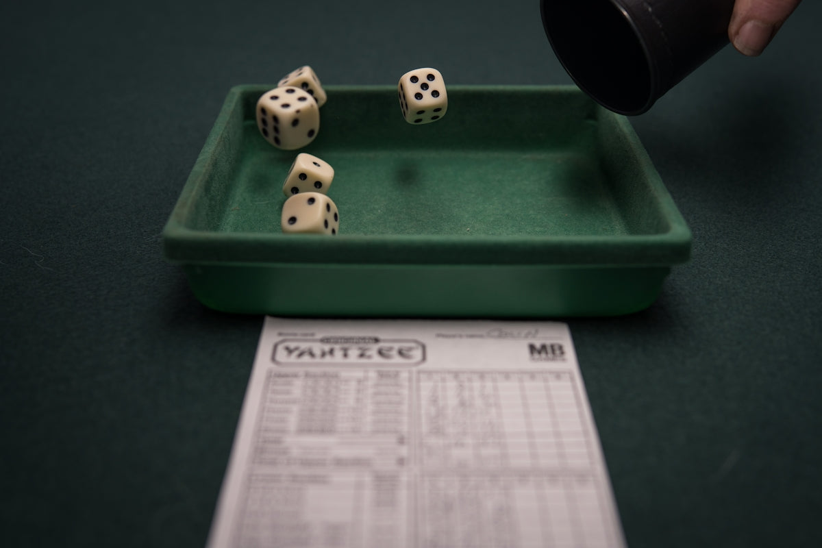 a green tray with dices on top of it