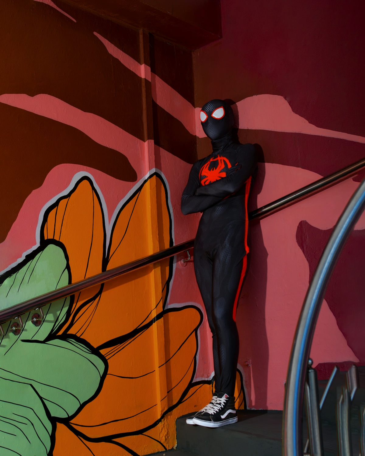 a man in a spider suit standing on a stair case