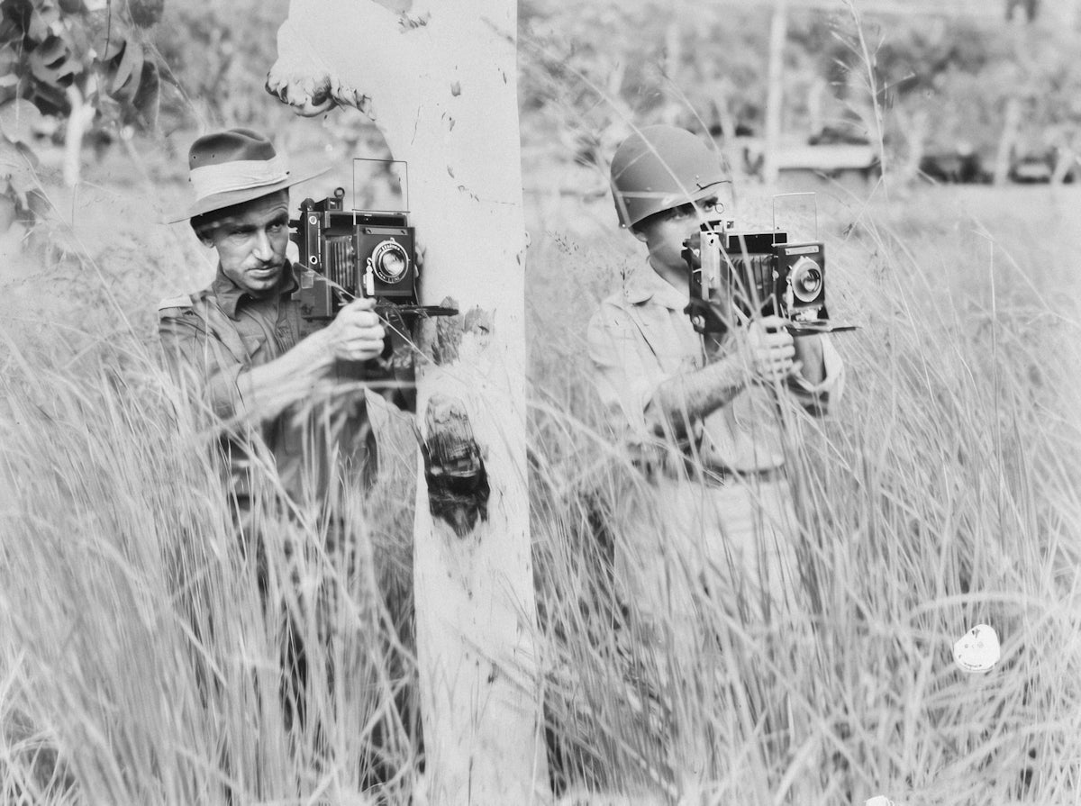 a couple of men standing next to each other in a field