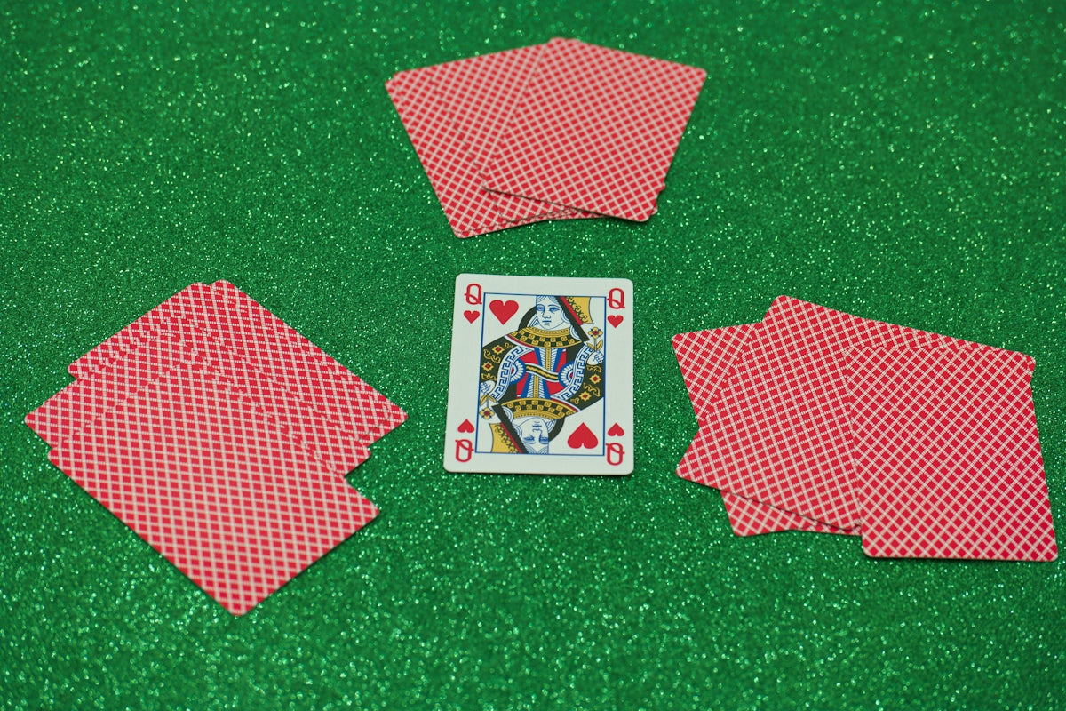 a set of four playing cards sitting on top of a green table