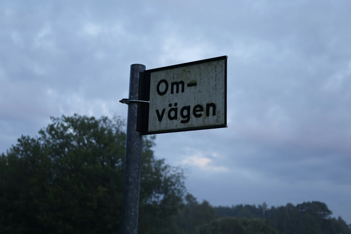 a street sign on a pole with trees in the background