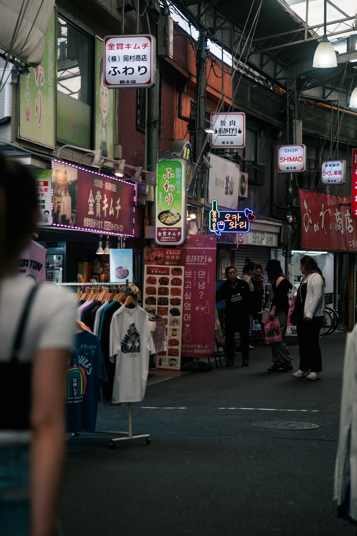 A woman walking down a street next to tall buildings