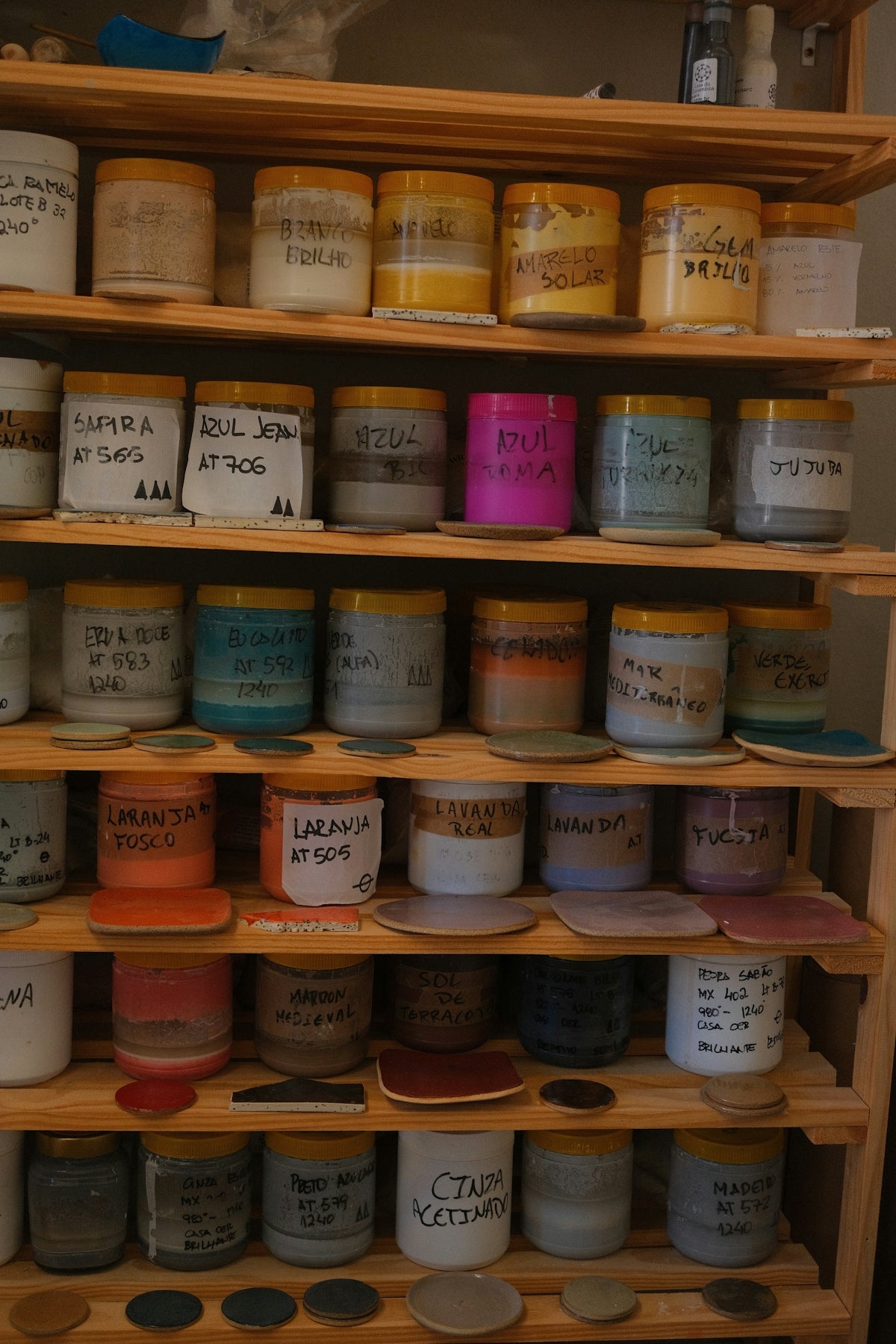 A wooden shelf filled with lots of different types of paint