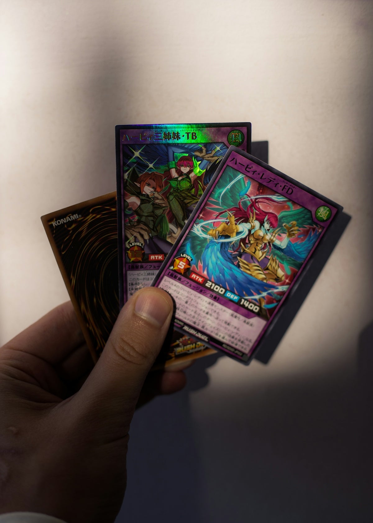 Hand holding several yu-gi-oh! trading cards.
