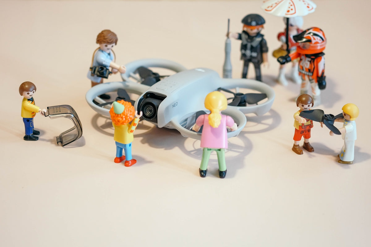 Playmobil figures are observing a drone.