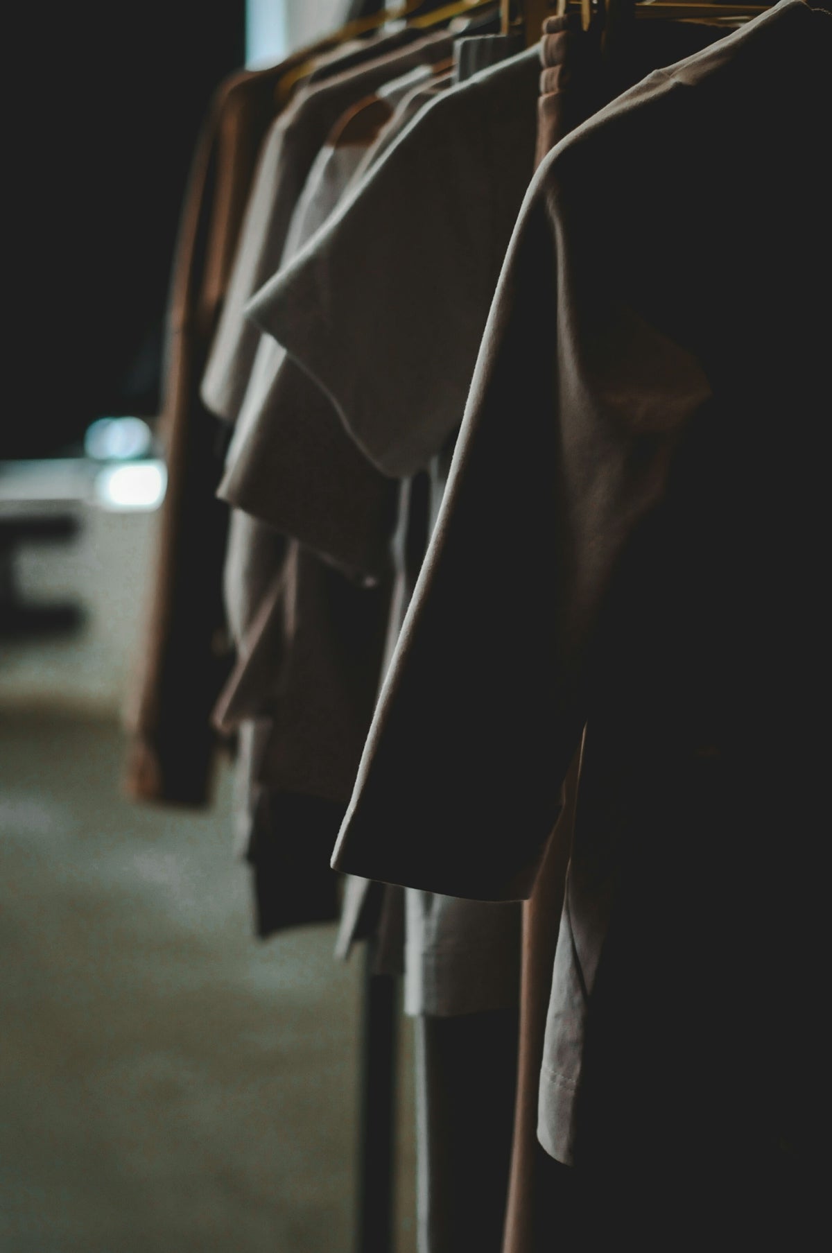 Clothes hang neatly on a rack in a store.