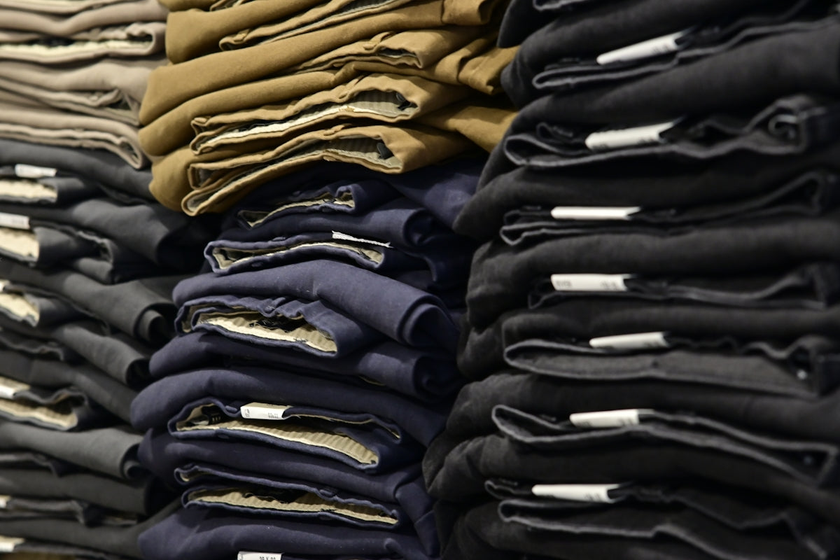 Piles of folded pants neatly stacked on shelves.