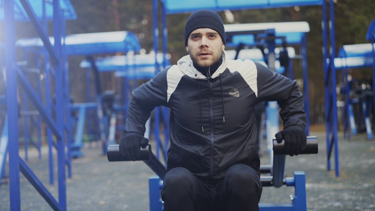 Man exercising outdoors on gym equipment