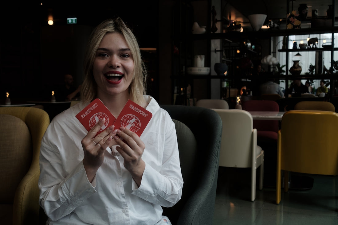 Young woman holds two red passports smiling faces cards
