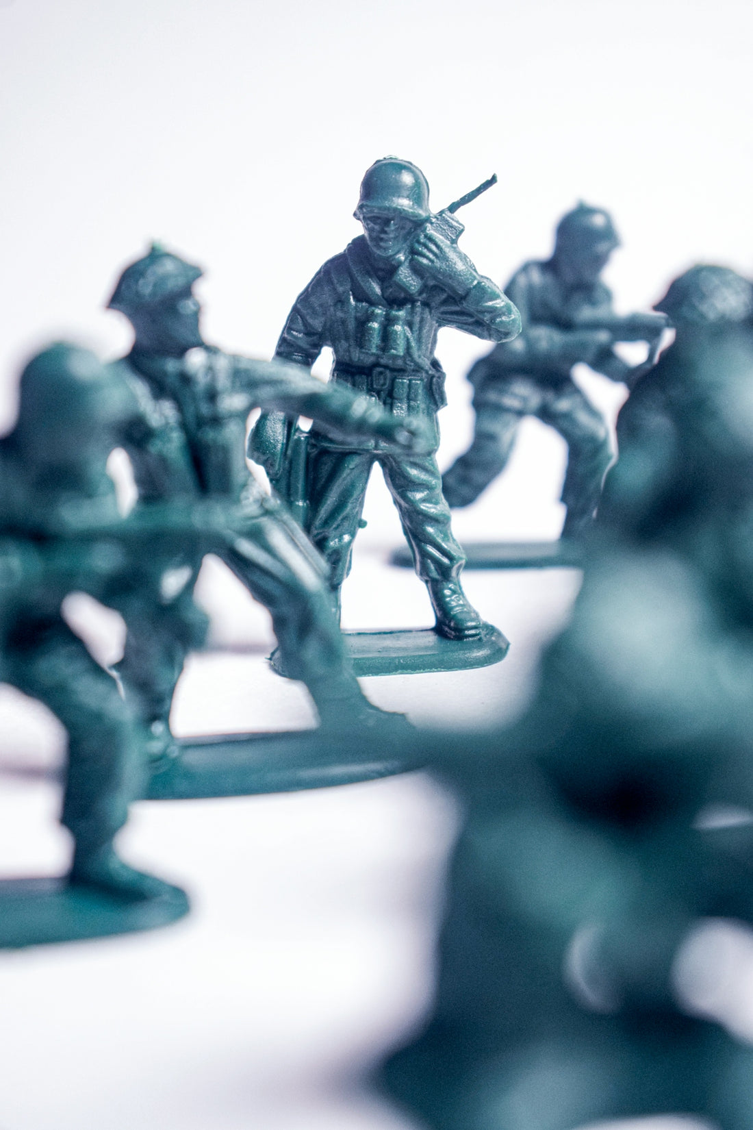 Green plastic army men in formation on white background